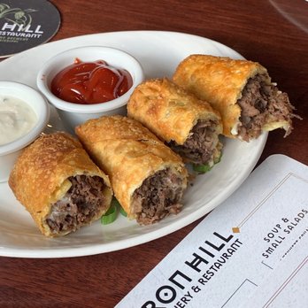 Iron Hill Brewery & Restaurant signature dishes Cheesesteak Egg Rolls, Voodoo Chicken Flatbread, Baja Fish Tacos, Brewski Burger